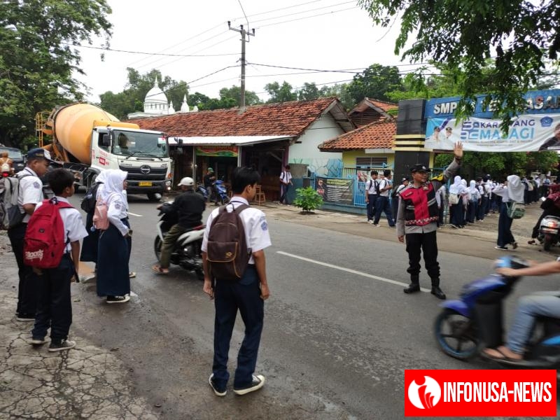 Bhabinkamtibmas Polsek Telagasari Bantu Siswa Menyebrang Saat Gatur Pagi
