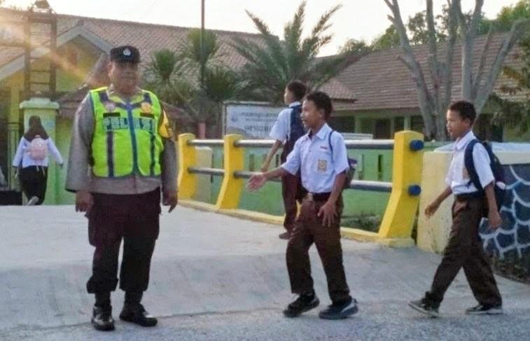 Polisi Sigap Kapolsek Pakisjaya IPTU Saefurohman SH Membantu Menyeberangkan Anak Sekolah