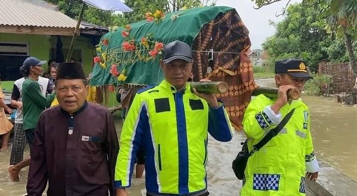 Di Tengah Banjir, Kapolsek Pamanukan Turun Tangan Gotong Keranda Jenazah Warga 