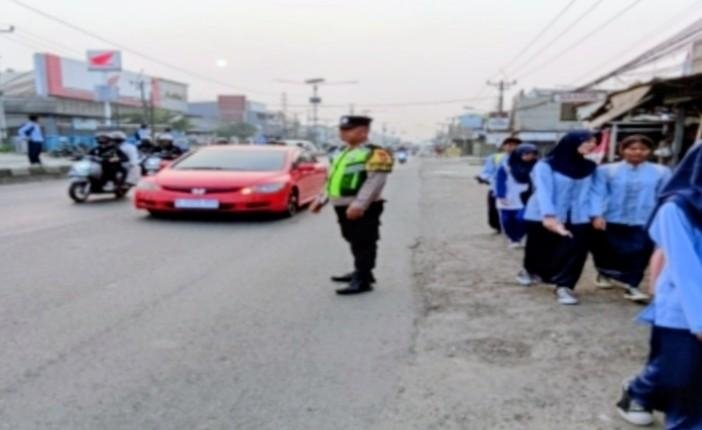 Sapa Pagi, Personel Polsek Klari Hadir di Tengah Masyarakat, Bantu Seberangkan Pengguna Jalan