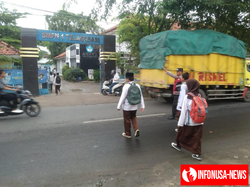 Bhabinkamtibmas Polsek Telagasari Pastikan Siswa Menyebrang dengan Aman Saat Gatur Pagi