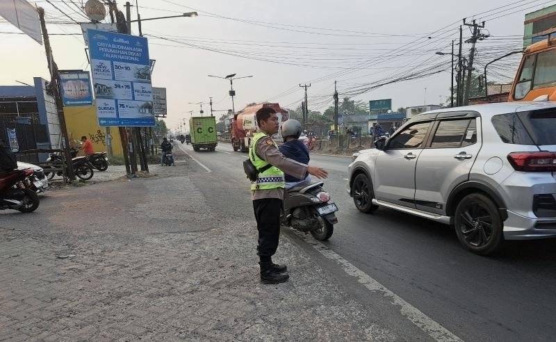 Sapa Pagi, Personel Polsek Klari Bantu Warga dan Pelajar Menyeberang di Jalan Raya Pantura Kosambi