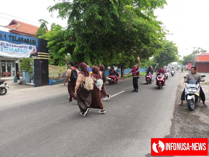 Aiptu Yosep Bhabinkamtibmas Polsek Telagasari Bantu Siswa Menyebrang Saat Gatur Pagi