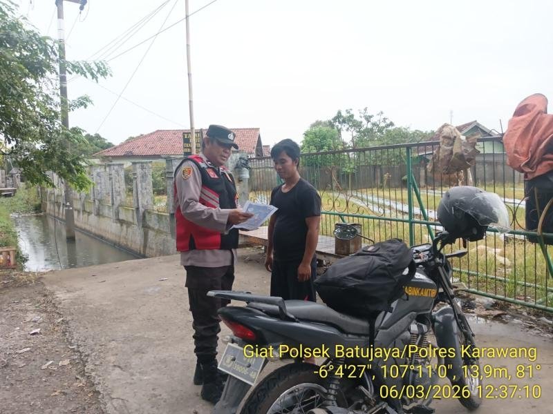 Anggota Polsek Batujaya mensosialisasikan QR Code Div Propam Polri Masyarakat Desa Telukambulu