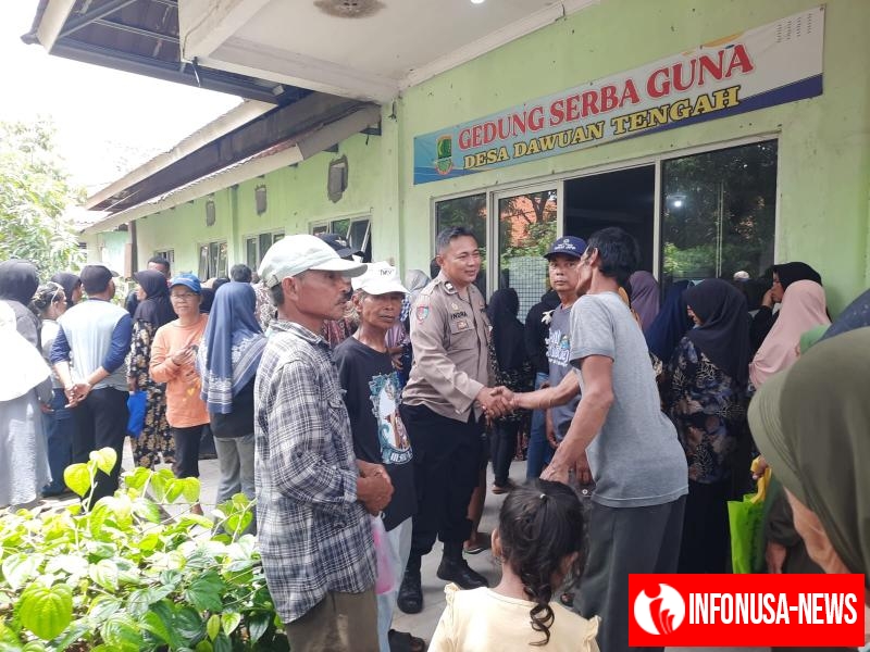 Personil Polsek Cikampek Aiptu Indra Beri Rasa Aman Pembagian Kartu ATM Penerima PKH dan BPNT di Kantor Desa Dawuan Tengah