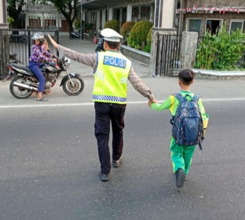 Pelayanan Sapa Pagi Polsek Cikampek Bripka Ajis Sebrangkan Anak Sekolah