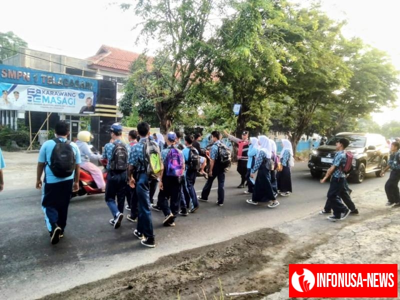 Bhabinkamtibmas Polsek Telagasari Sebrangkan Siswa Saat Gatur Pagi