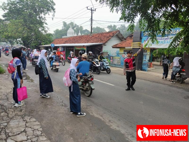 Bhabinkamtibmas Polsek Telagasari Aiptu Yosep Bantu Siswa Menyebrang Saat Gatur Pagi