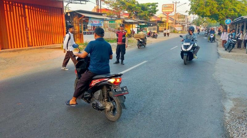 Laksanakan Pelayanan Bagi Masyarakat, Bhabinkamtibmas Polsek Telagasari Bantu Siswa Menyebrang