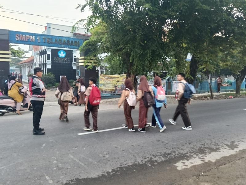 Laksanakan Gatur Pagi, Personil Polsek Telagasari Bantu Siswa Menyebrang dengan Aman