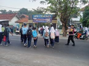 Bhabinkamtibmas Polsek Telagasari Pastikan Kondusifitas Arulin dan Bantu Siswa Menyebrang
