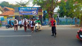 Laksanakan Pelayanan Bagi Masyarakat, Bhabinkamtibmas Polsek Telagasari Bantu Siswa Menyebrang