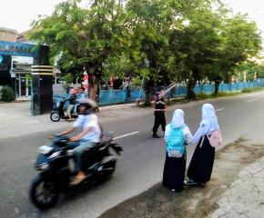 Bhabinkamtibmas Polsek Telagasari Bantu Siswa Menyebrang Saat Gatur