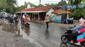 Bhabinkamtibmas Polsek Telagasari Bantu Siswa Menyebrang Saat Gatur Pagi
