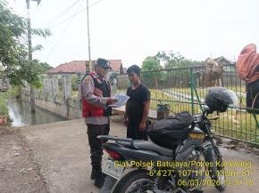 Anggota Polsek Batujaya mensosialisasikan QR Code Div Propam Polri Masyarakat Desa Telukambulu