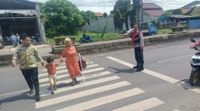 Anggota Unit Samapta Polsek Klari Bantu Pejalan Kaki Menyeberang Jalan