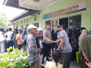 Personil Polsek Cikampek Aiptu Indra Beri Rasa Aman Pembagian Kartu ATM Penerima PKH dan BPNT di Kantor Desa Dawuan Tengah
