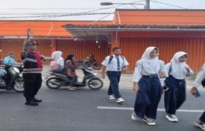 Bhabinkamtibmas Polsek Telagasari Bantu Sebrangkan Siswa Saat Gatur